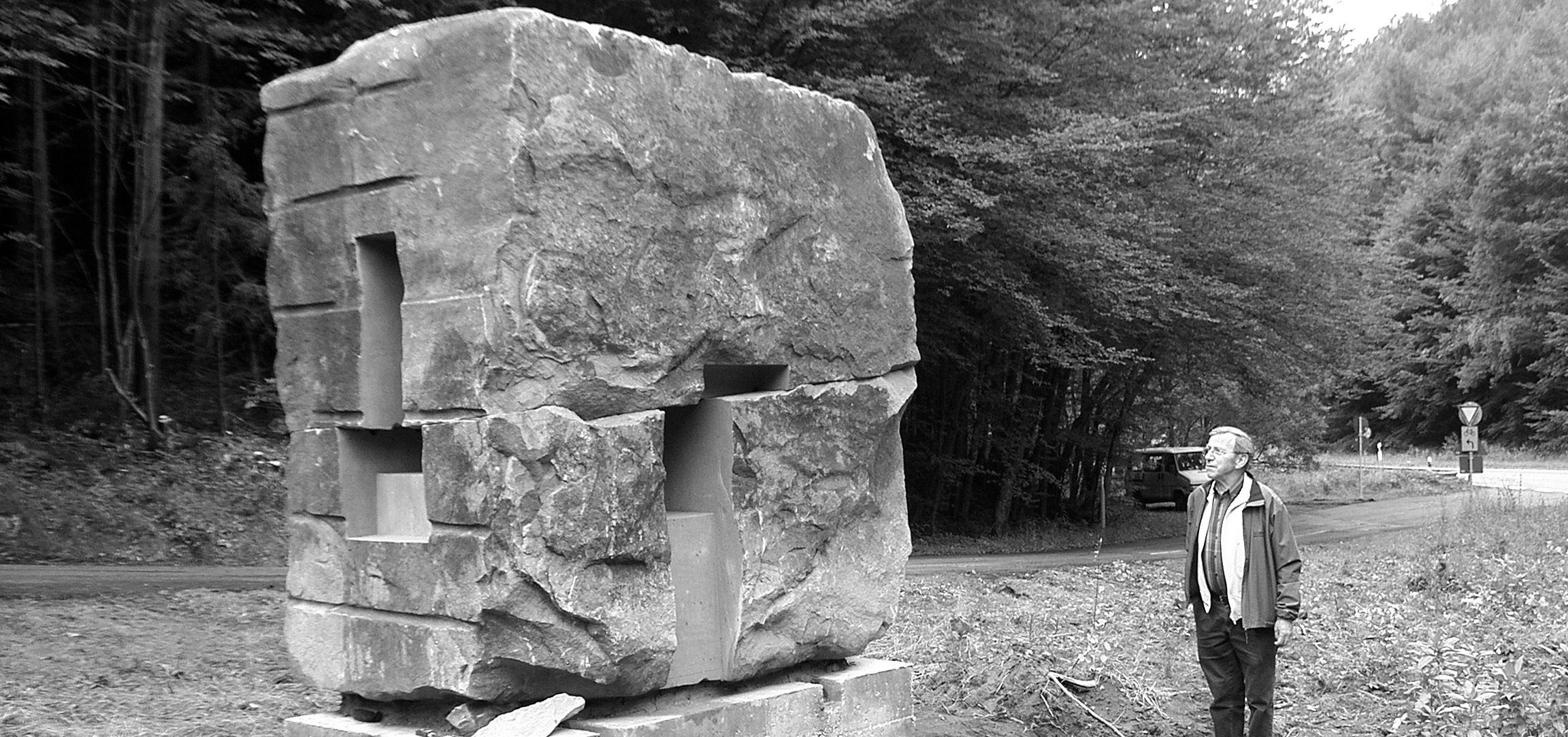 Uli Gsell steht neben einer monumentalen Steinskulptur