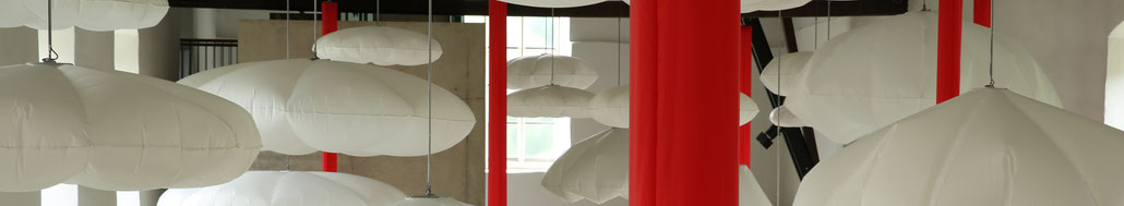 Luftgefüllte Kissen hängen in einem Ausstellungsraum an der Decke